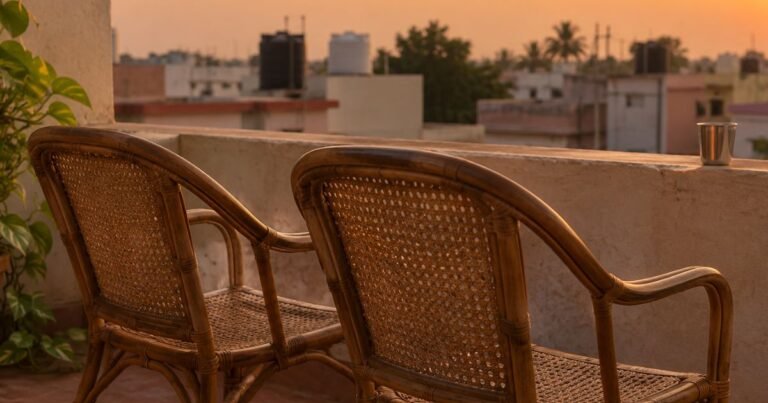 Two empty cane chairs side by side on a terrace at sunset, facing the rooftops, a quiet place to think about how to talk to your teenager about their future